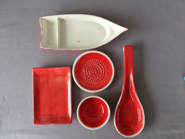Keramikartikel in rot Schiffchen, Löffel, Reibe und Teller, passend zur Keramikschale